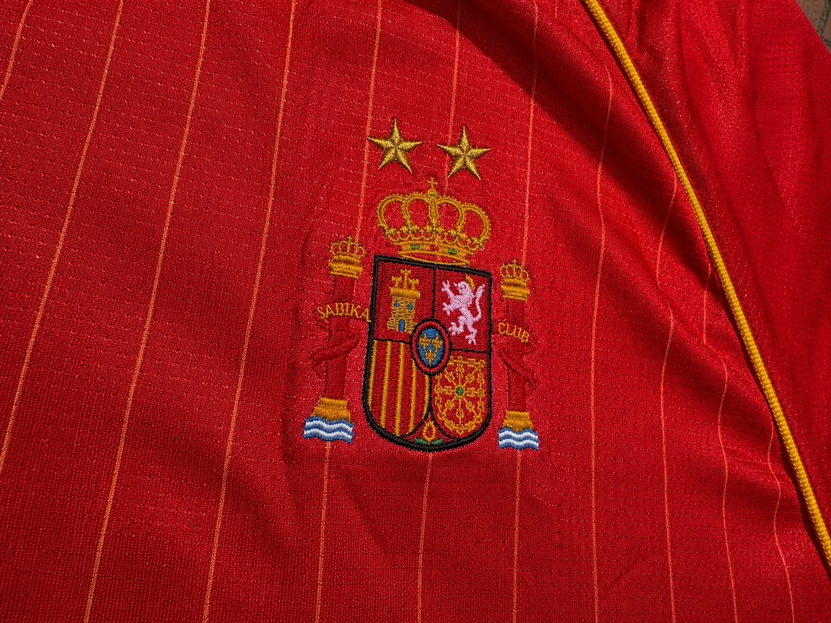 Detalle de escudo bordado sobre camiseta Sabika